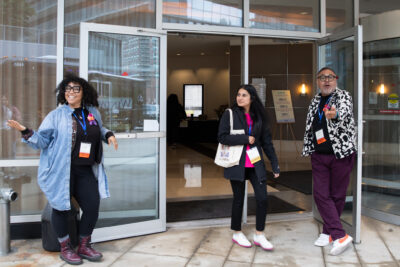 Volunteers at the conference center welcoming attendees back from their site visits.