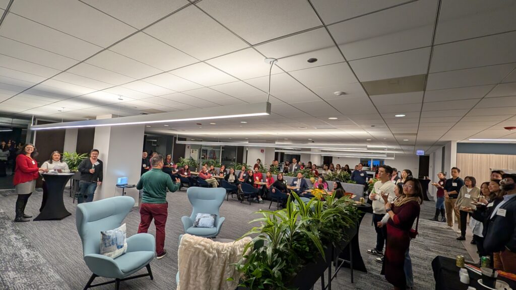 a large room with people listening to a speaker