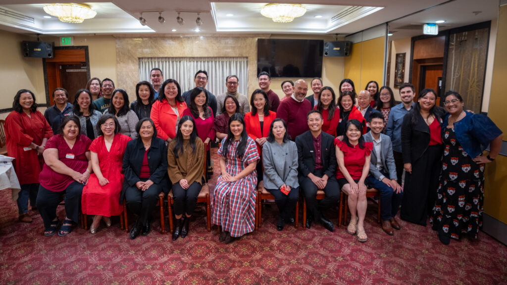 group of attendees at a banquet taking a group photo smiling