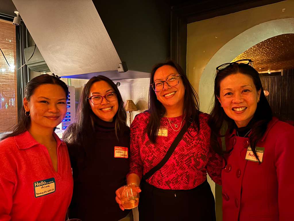 4 people taking a group photo smiling at the camera